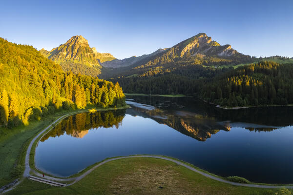 Aerial view of Barensoolspitz and Brunnelistock peaks at sunrise reflected in the Obersee lake. Näfels, Oberseealp, Canton of  Glarus, Switzerland.