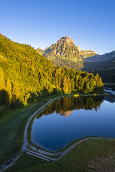 Aerial view of Barensoolspitz and Brunnelistock peaks at sunrise reflected in the Obersee lake. Näfels, Oberseealp, Canton of  Glarus, Switzerland.