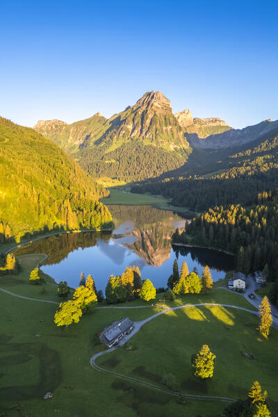 Aerial view of Barensoolspitz and Brunnelistock peaks at sunrise reflected in the Obersee lake. Näfels, Oberseealp, Canton of  Glarus, Switzerland.