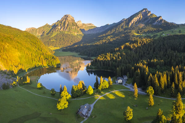 Aerial view of Barensoolspitz and Brunnelistock peaks at sunrise reflected in the Obersee lake. Näfels, Oberseealp, Canton of  Glarus, Switzerland.