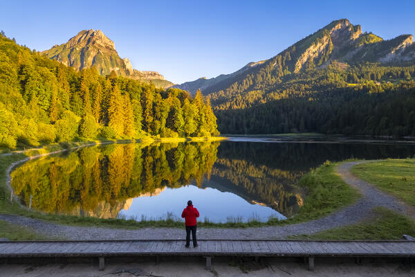 Aerial view of Barensoolspitz and Brunnelistock peaks at sunrise reflected in the Obersee lake. Näfels, Oberseealp, Canton of  Glarus, Switzerland.