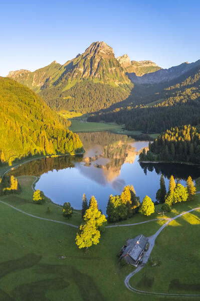 Aerial view of Barensoolspitz and Brunnelistock peaks at sunrise reflected in the Obersee lake. Näfels, Oberseealp, Canton of  Glarus, Switzerland.