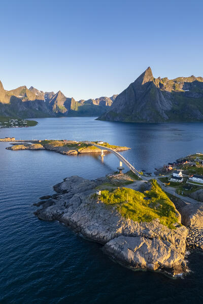 Aerial view of the Hamnøya island and the Lilandstinden mountain in Reine Bay during summer sunrise at midnight sun. Lofoten Islands, Norway.