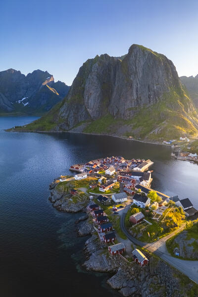 Aerial view of the Hamnøya island and the Lilandstinden mountain in Reine Bay during summer sunrise at midnight sun. Lofoten Islands, Norway.