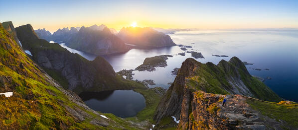 Aerial view of a sunrise at the top of Reinebringen mountain in summer during midnight sun. Reine, Moskenes, Nordland, Lofoten Islands, Norway.