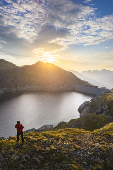 Aerial view of a person admiring Lago Nero during summer time at sunrise. Valgoglio, Val Seriana, Bergamo district, Lombardy, Italy, Southern Europe.