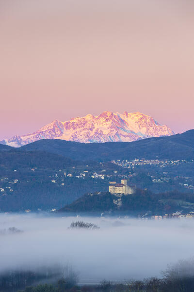 View of the fortress called Rocca di Angera during a winter sunrise with Monte Rosa in the background. Taino, Lake Maggiore, Varese district, Lombardy, Italy.