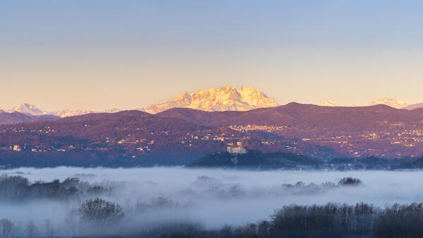 View of the fortress called Rocca di Angera during a winter sunrise with Monte Rosa in the background. Taino, Lake Maggiore, Varese district, Lombardy, Italy.