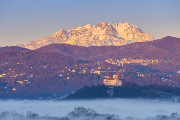 View of the fortress called Rocca di Angera during a winter sunrise with Monte Rosa in the background. Taino, Lake Maggiore, Varese district, Lombardy, Italy.