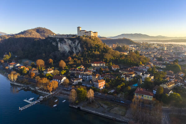 Aerial view of the fortress called Rocca di Angera during a winter sunrise surrounded by mist. Angera, Lake Maggiore, Varese district, Lombardy, Italy.