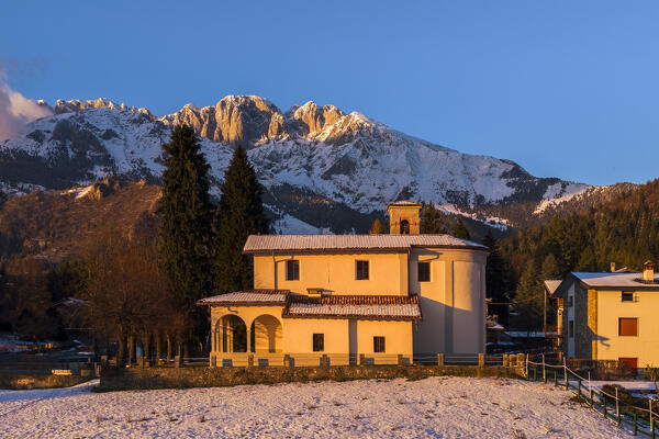 Aerial view of the Santuario di Lantana church and the Presolana covered in snow. Castione della Presolana, Seriana Valley, Bergamo province, Lombardy, Italy.