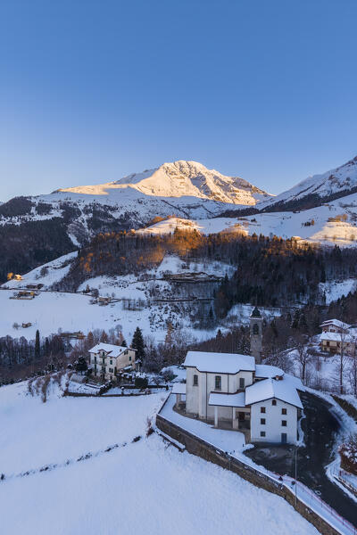 Aerial view of Zambla at sunrise after a snowfall in winter. Val Serina, Zambla Alta, Bergamo district, Lombardy, Italy, Southern Europe.