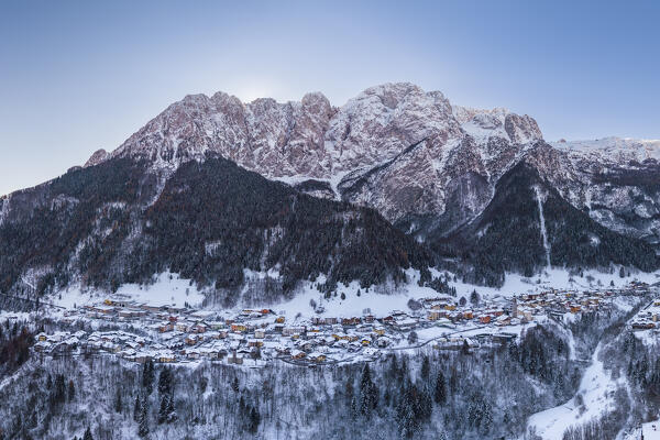 Aerial view of the small church called Cesulì in Colere town with view of the north face of the Presolana mountain in winter after a snowfall. Colere, Val di Scalve, Bergamo district, Lombardy, Italy, Southern Europe.