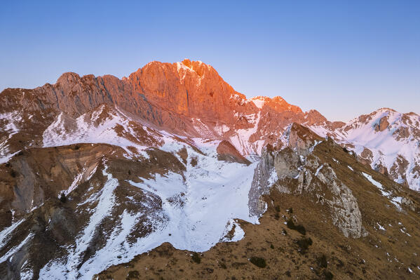 Aerial view of Rino Olmo refuge and Passo Olone with Pizzo della Presolana during a winter sunset. Castione della Presolana, Bergamo province, upper Val Seriana, Lombardy, Italy.