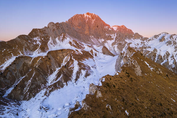Aerial view of Rino Olmo refuge and Passo Olone with Pizzo della Presolana during a winter sunset. Castione della Presolana, Bergamo province, upper Val Seriana, Lombardy, Italy.