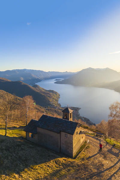 Aerial view of a sunset on Lake Como at the church of San Girolamo located in Alpe Camaggiore. Vendrogno, Bellano, Lecco province, Lombardy, Italy, Europe.