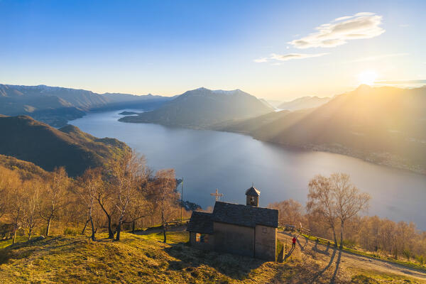 Aerial view of a sunset on Lake Como at the church of San Girolamo located in Alpe Camaggiore. Vendrogno, Bellano, Lecco province, Lombardy, Italy, Europe.