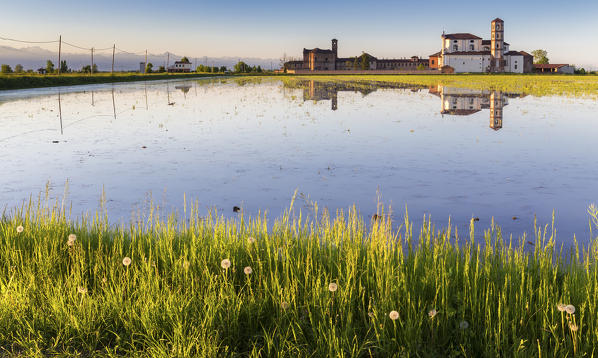 Sunset over rice fields and the abbey of Lucedio. Trino Vercellese, Piedmont, Italy.