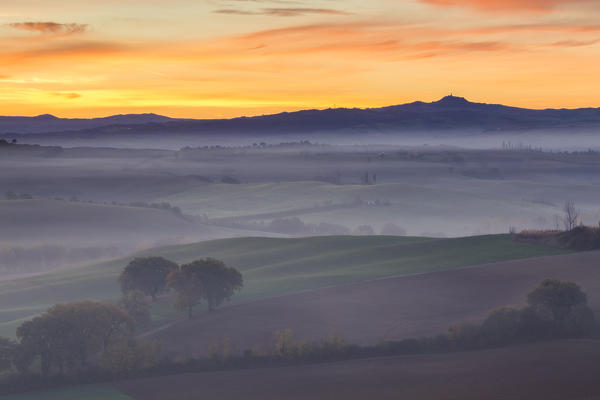 Fields and fog near Podere Belvedere at sunrise, San Quirico d'Orcia, Val d'Orcia, Tuscany, Italy.
