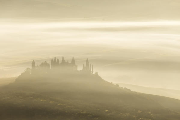 The autumnal fogs surround Podere Belvedere at dawn, San Quirico d'Orcia, Val d'Orcia, Tuscany, Italy.
