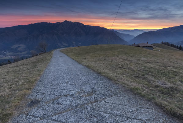 Winter sunset at the huts of Monte Alino over the town of Parre, Val Seriana, Bergamo province, Lombardy, Italy.