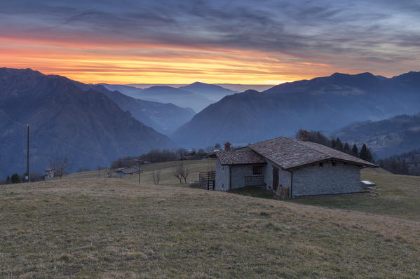 Winter sunset at the huts of Monte Alino over the town of Parre, Val Seriana, Bergamo province, Lombardy, Italy.