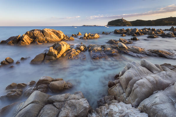 Sunset on the reef of Porto Giunco beach and the old tower, Villasimius, Cagliari, Sardinia, Italy, Europe.