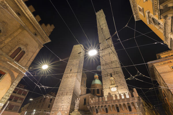View of the Torre degli Asinelli and Torre della Garisenda from Piazza di Porta Ravegnana square at night. Bologna, Emilia Romagna, Italy.