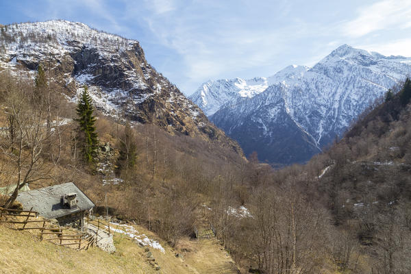 View of a hut and the mountains of Valle Antrona from Alpe Cheggio, Antrona Valley, Piedmont, Italy.