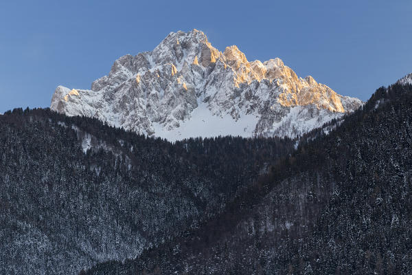 View of Pizzo Camino from Schilpario during a winter sunset. Schilpario, Val di Scalve, Bergamo district, Lombardy, Italy.