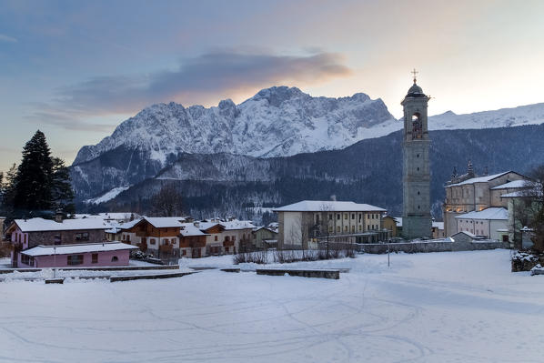 View of Presolana and the Vilminore church during a winter sunset. Vilminore, Val di Scalve, Bergamo district, Lombardy, Italy.
