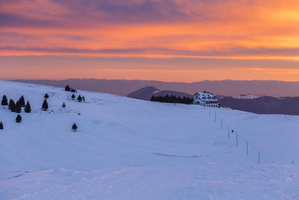 View of the Magnolini refuge during a winter sunset from Monte Pora, Val Seriana, Bergamo district, Lombardy, Italy.