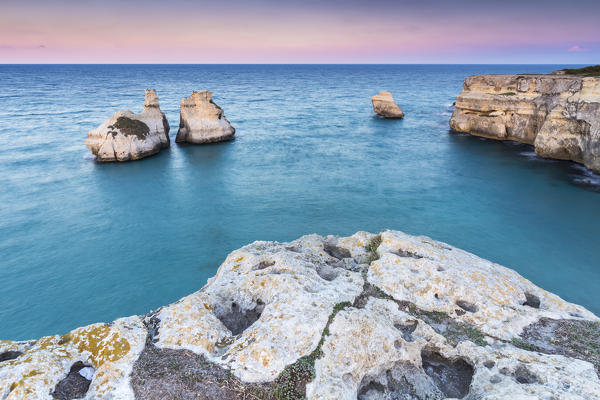 The Two Sisters stacks in front of the shore of Torre dell'Orso. Melendugno, province of Lecce, Salento, Apulia, Italy.