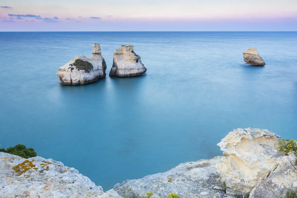 The Two Sisters stacks in front of the shore of Torre dell'Orso. Melendugno, province of Lecce, Salento, Apulia, Italy.
