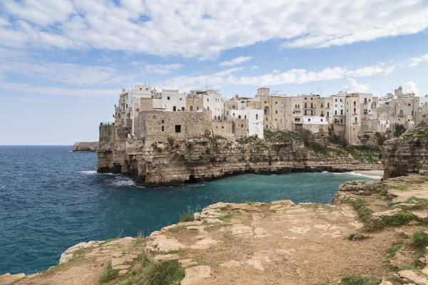 View of the overhanging houses of Polignano a Mare from the cliff in front of the town. Bari district, Apulia, Italy, Europe.