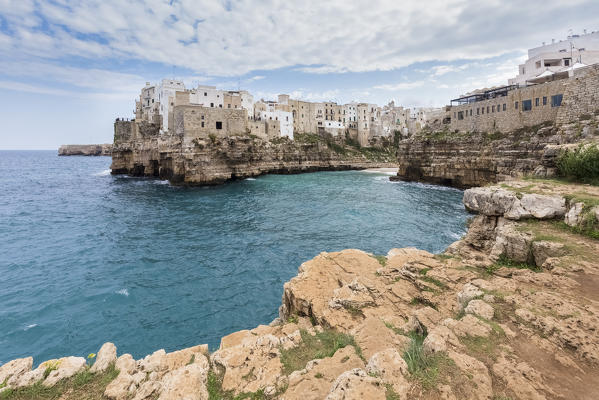 View of the overhanging houses of Polignano a Mare from the cliff in front of the town. Bari district, Apulia, Italy, Europe.