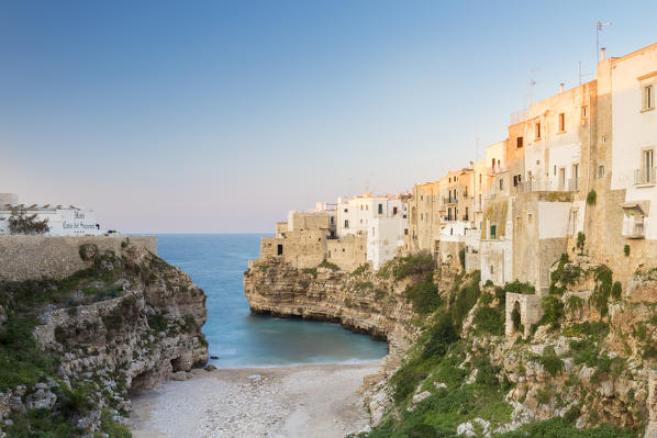 View of the cove Lama Monachile Cala Porto of Polignano a Mare at sunset. Bari district, Apulia, Italy, Europe.