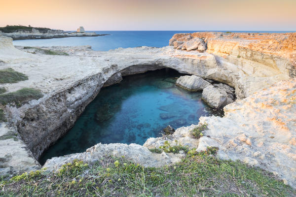 View of a sunset at the Grotta della Poesia cave in Roca Vecchia, near Torre dell'Orso. Melendugno, province of Lecce, Salento, Apulia, Italy.