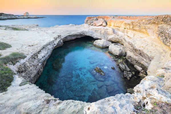 View of a sunset at the Grotta della Poesia cave in Roca Vecchia, near Torre dell'Orso. Melendugno, province of Lecce, Salento, Apulia, Italy.