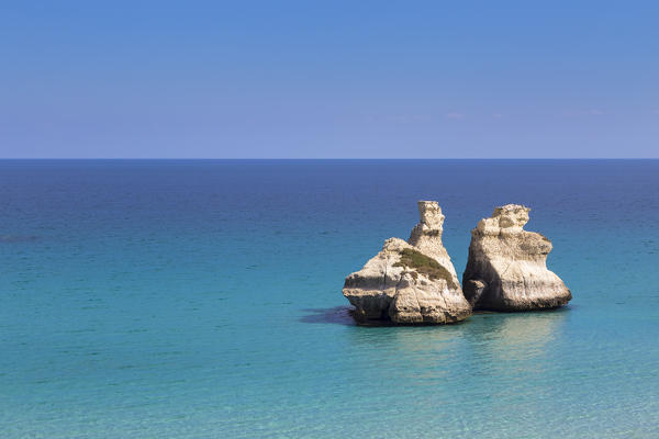 The Two Sisters stacks in front of the shore of Torre dell'Orso. Melendugno, province of Lecce, Salento, Apulia, Italy.
