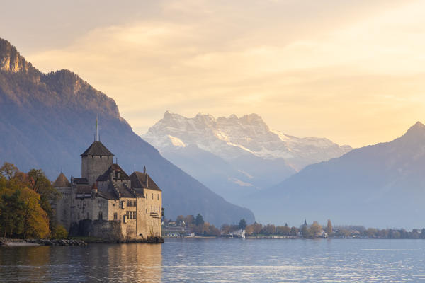 View of the Chillon castle on Lake Geneva and Dents du Midi at sunset. Veytaux, Montreux, Canton of Vaud, Switzerland.