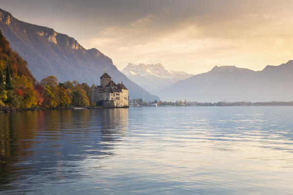 View of the Chillon castle on Lake Geneva and Dents du Midi at sunset. Veytaux, Montreux, Canton of Vaud, Switzerland.