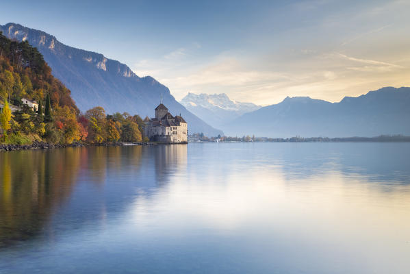 View of the Chillon castle on Lake Geneva and Dents du Midi at sunset. Veytaux, Montreux, Canton of Vaud, Switzerland.