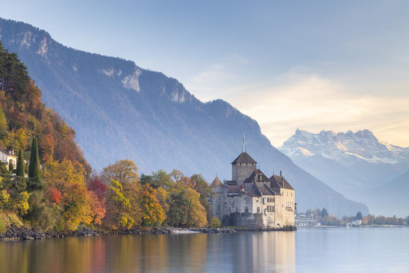 View of the Chillon castle on Lake Geneva and Dents du Midi at sunset. Veytaux, Montreux, Canton of Vaud, Switzerland.