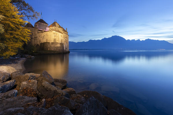 View of the Chillon castle on Lake Geneva at the blue hour. Veytaux, Montreux, Canton of Vaud, Switzerland.