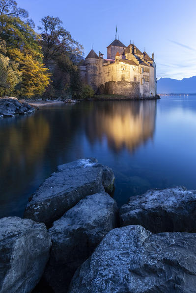 View of the Chillon castle on Lake Geneva at the blue hour. Veytaux, Montreux, Canton of Vaud, Switzerland.