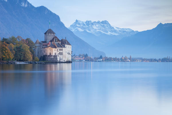 View of the Chillon castle on Lake Geneva and Dents du Midi at sunset. Veytaux, Montreux, Canton of Vaud, Switzerland.