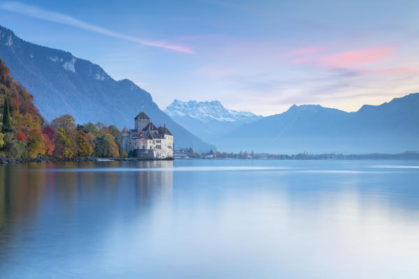 View of the Chillon castle on Lake Geneva and Dents du Midi at sunset. Veytaux, Montreux, Canton of Vaud, Switzerland.