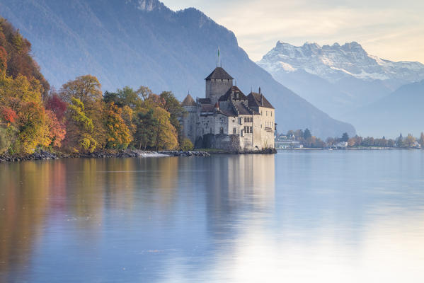View of the Chillon castle on Lake Geneva and Dents du Midi at sunset. Veytaux, Montreux, Canton of Vaud, Switzerland.
