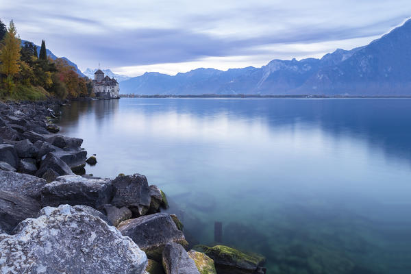 View of the Chillon castle on Lake Geneva and Dents du Midi at sunrise. Veytaux, Montreux, Canton of Vaud, Switzerland.